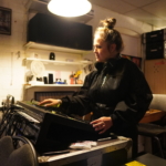 A woman adjusts the settings on the sound desk during the rehearsal.