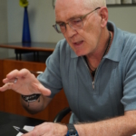 Steve Bassett speaks during a virtual interview, using one hand to emphasise his words and holding a pen in the other.